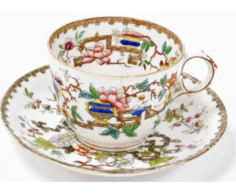 An early 20thC cup and saucer, in the Meissen style, decorated with flowers, leaves and urns, with a Greek key border, bearin