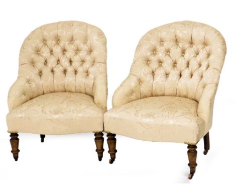 A pair of Victorian button back nursing chairs, upholstered in a cream coloured floral scroll fabric, with button back on oak