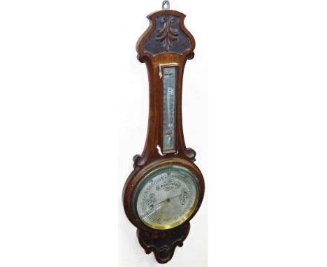 An oak cased mahogany wheel barometer, with a carved fleur de lis top, 82cm high.