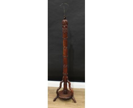 A Chinese hardwood standard lamp, carved with leafy bamboo and fruiting vine, circular tripod base, 157cm high 