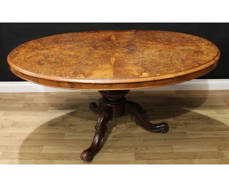 A Victorian burr walnut oval breakfast table, quarter-veneered top with moulded edge, turned pedestal, acanthus carved cabrio