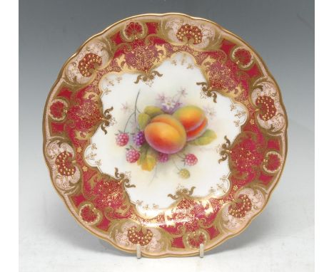 A Royal Worcester shaped circular plate, painted by Albert Shuck, signed, with ripe plums and raspberries, within fancy gilt 