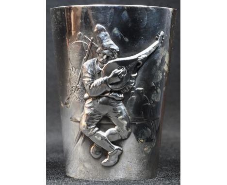 A German silver tapered cylindrical beaker, chased with a rustic playing a lute, gilt interior, 7.5cm high, halbmond und kron