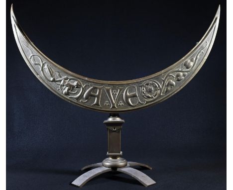 An Arts and Crafts beaten brass ecclesiastical crescent shaped seven light candelabrum, embossed 'Ave' and with stylised flow