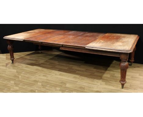 A Victorian mahogany wind-out dining table, rounded rectangular moulded top above a deep frieze, fluted baluster legs carved 