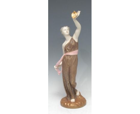 A Royal Worcester figure, Liberty, she stands holding a dove aloft, wearing flowing brown  robes, tied with a pink sash, pick