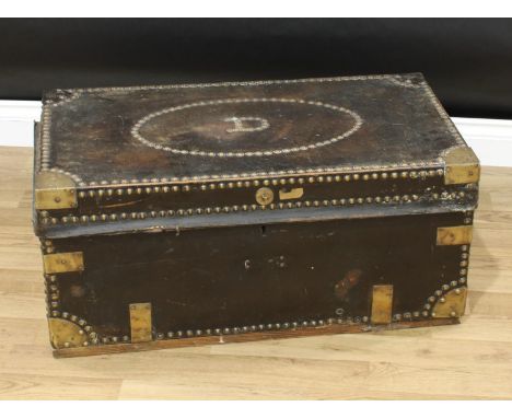 An 18th century brass bound leather travelling trunk, hinged cover, studded borders, swan neck carrying handles, paper label 