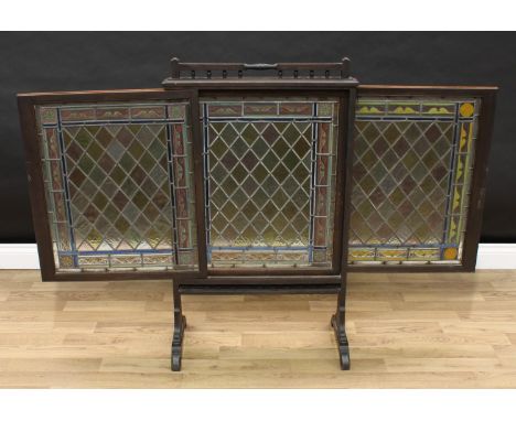 A Victorian firescreen, in the Reformed Gothic taste, the stained glass banner with lift-up central section flanked by slidin