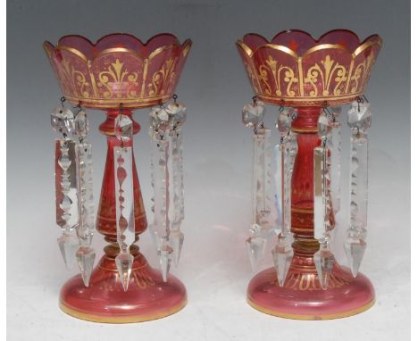 A pair of Victorian ruby lustres, applied with gilt scrolls, clear prismatic lustres, 25.5cm high, c.1870 