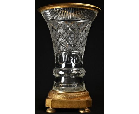 A 19th century ormolu mounted hobnail-cut clear glass trumpet shaped table centre vase, engine-turned socle, re-entrant squar