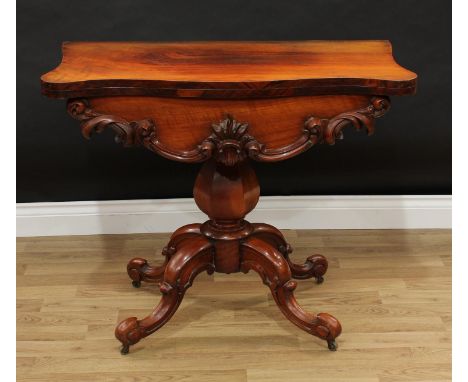 A Victorian walnut serpentine card table, folding top enclosing a baize lined playing surface above a deep frieze carved and 