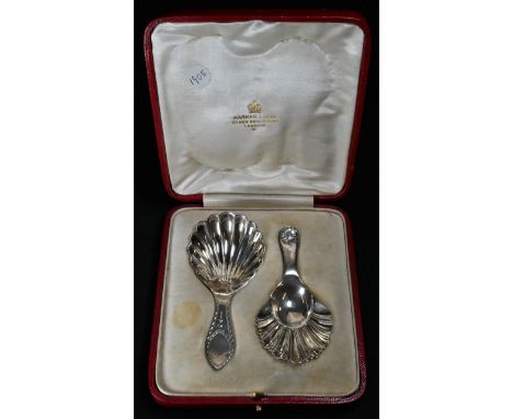 A case of Edwardian silver caddy spoons, of George III design, shell bowls, one bright-cut engraved, its companion with shell