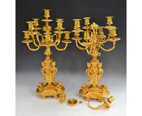 A pair of Louis XVI Revival gilt-metal nine-light table candelabrum, campana sconces, circular drip pans, the bases cast and 