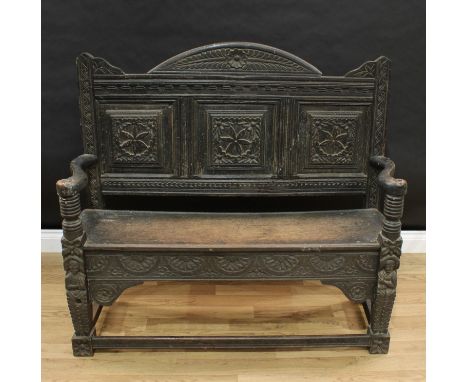 A 19th century oak hall bench, arched three-panel back profusely carved in the 17th century taste, plank seat above a frieze 