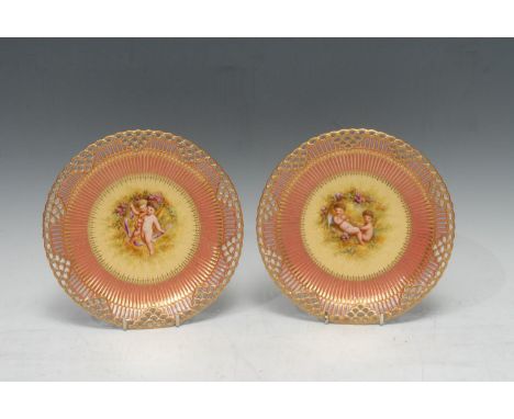 A pair of Royal Crown Derby reticulated cabinet plates, painted by R Hague, signed, painted with two putti amongst roses, the