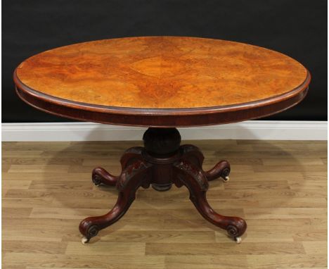 A Victorian burr walnut oval breakfast table, quarter-veneered top above a deep frieze, baluster column, cabriole legs carved