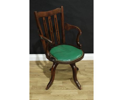 A late 19th century swivel desk chair, shaped cresting rail, tapered back with three pierced splats, incurved arms, brass stu