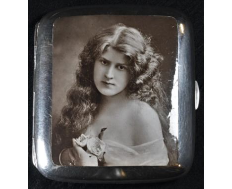 An Edwardian silver and enamel curved rounded rectangular cigarette case, hinged cover decorated with a sepia photographic po