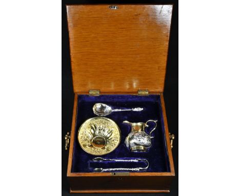 A 19th century Continental silver-gilt cream jug and sugar basin, possibly Russian, chased with flowers, and putto masks, the