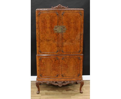 A Queen Anne Revival burr walnut cocktail cabinet, rectangular doors enclosing a fitted interior, the slightly projecting bas