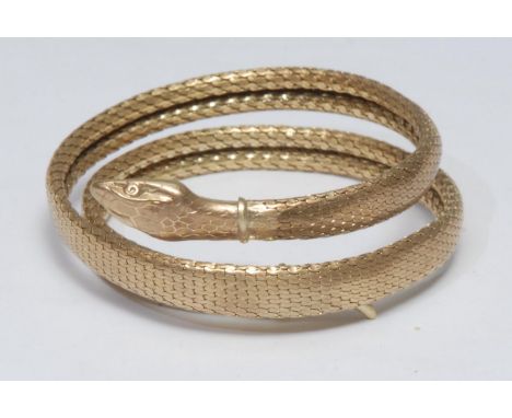 A gilt metal snake bangle, coiled articulated unmarked scale mesh body, 40.6g gross 