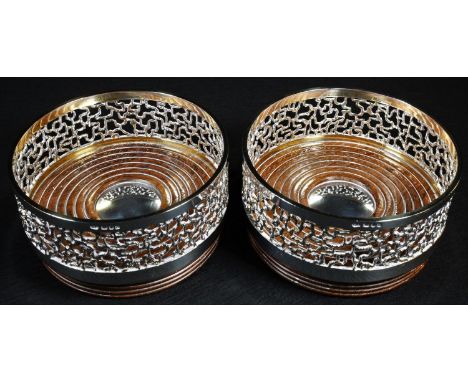 Stuart Devlin (1931 - 2018)  - a pair of Elizabeth II silver cylindrical wine coasters, textured filigree borders, gilt lines