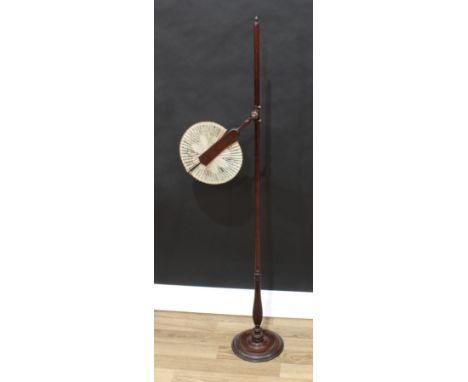 An unusual George III mahogany floor standing face screen, the folding fan shaped silk banner adjustable on a turned pillar, 