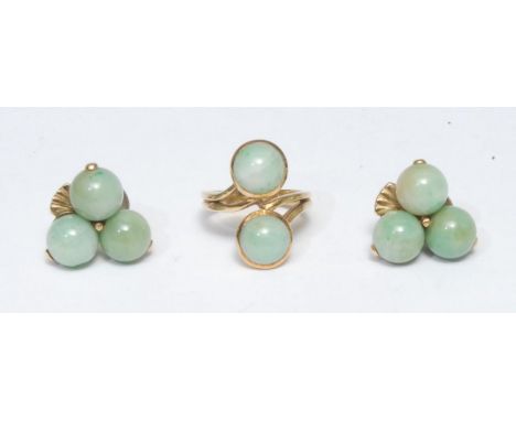 A jade green cabochon set twist ring, cross over crest of two jade green round cabochons, tapering open shoulders, yellow met