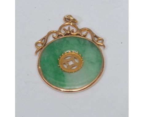 A jade disc pendant, flat jade multi-tone ring with central pierced window, collar surround with scrolling crest, unmarked ye