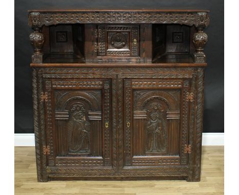 A '17th century' oak duodarn, oversailing top with a frieze of stylised leaves above a pair of leaf-capped baluster pillars a