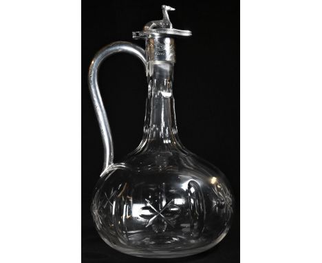 A Victorian silver mounted cut glass onion shaped claret jug, hinged cover surmounted by a canine finial cast as a recumbent 