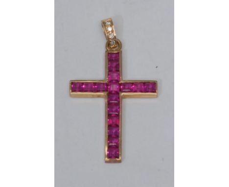 A synthetic ruby and diamond Crucifix pendant, channel set with square cut pink synthetic rubies beneath a diamond accented s