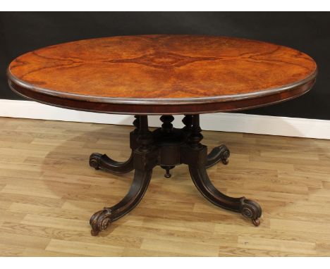 A Victorian burr walnut oval breakfast table, quarter veneered top above a deep frieze, turned quatre-columnar base, sabre le