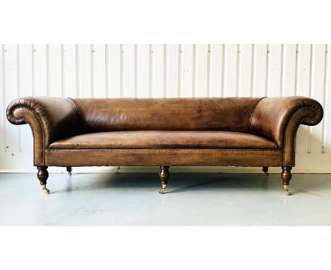 GEORGE SMITH SOFA, hand finished mid tan leather upholstered with studded scroll arms and turned supports with castors, 260cm