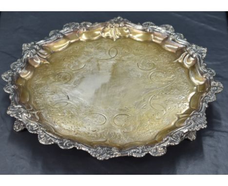 A Victorian silver salver of circular form with gadrooned rim and ornamental shell and scroll border, the interior engraved w