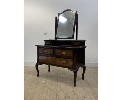 A late Victorian figured walnut dressing table, the swing mirror over two trinket drawers, with two short and a long drawer u