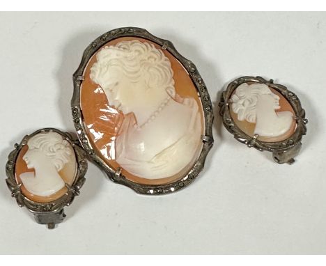 A white metal marcasite mounted oval shell carved cameo depicting a portrait of a lady complete with safety chain and a pair 