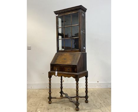 An early 20th century oak bureau bookcase, the dentil cornice over glazed cabinet, fall front with fitted interior, above a d