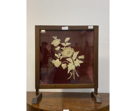 An early 20th century glazed oak fire screen, the stitched silk and velvet panel worked in a floral design, W21cm