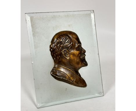 A rectangular frosted glass panel containing a plaster silhouette of Lenin with applied gilt decoration, on easel stand, (20c