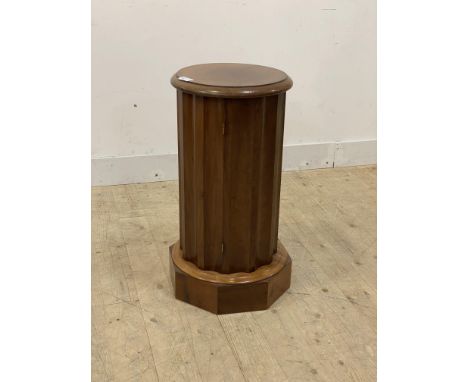 A Victorian walnut and mahogany cylinder commode or night stand, the moulded top over fluted case with concealed door enclosi