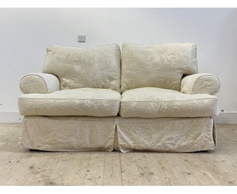 A traditional two seat sofa, upholstered in a fitted white demask cover, raised on turned bun supports, retailed by John Lewi