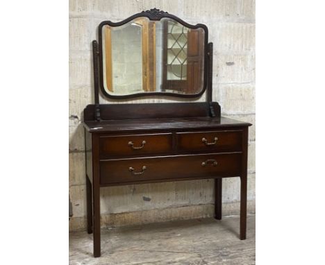 An early 20th century mahogany dressing chest, the swing mirror over two short and one long drawer, raised on square section 