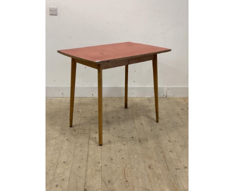 A mid century kitchen table, the red formica top raised on light beech splayed and tapered supports, H78cm, W93cm, D61cm