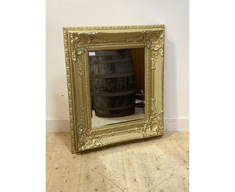 An ornate gilt framed wall mirror in the Rococo style, each corner decorated with shells and scrolling acanthus enclosing a b