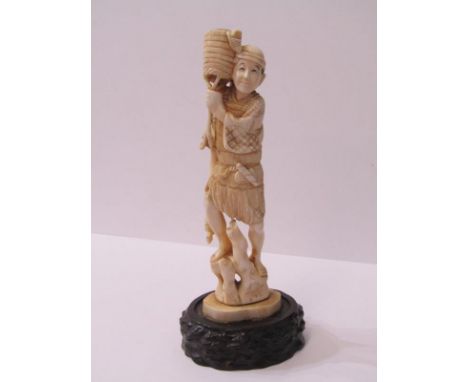 ANTIQUE IVORY FIGURE, Fisherman with trident and basket on carved wooden base 