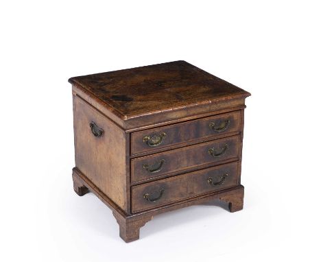 An antique and later walnut small chest of three drawers with brass carrying handles, brass ring handles and raised on bracke