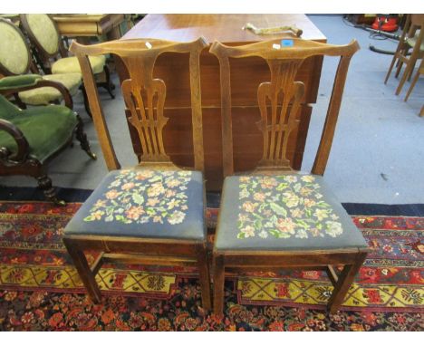 Two late Georgian dining chairs with pierced central splats, tapestry upholstered drop-in seats, square legs united by H-stre