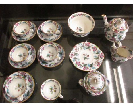 A Victorian dolls part tea set decorated with flowering vines, comprising six cups, five saucers, a teapot, a lidded sugar bo