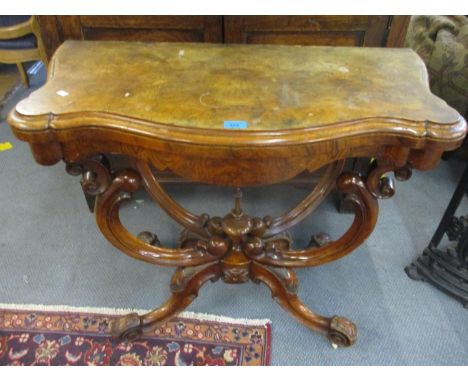 A Victorian walnut foldover card table having scroll shape supports on a quatrefoil base 73cm h x 92 cm w 